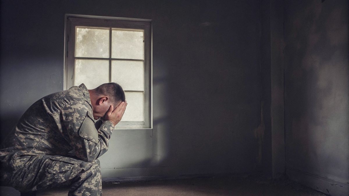 A veteran with PTSD is sitting alone in his room
