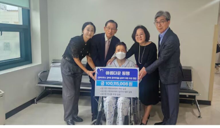 The article's feature image showing Lee Tae-young, chairman of the residents' committee, second from left, and other residents of Apgujeong Hyundai Apartment are handing over a donation to Kim Mi-suk